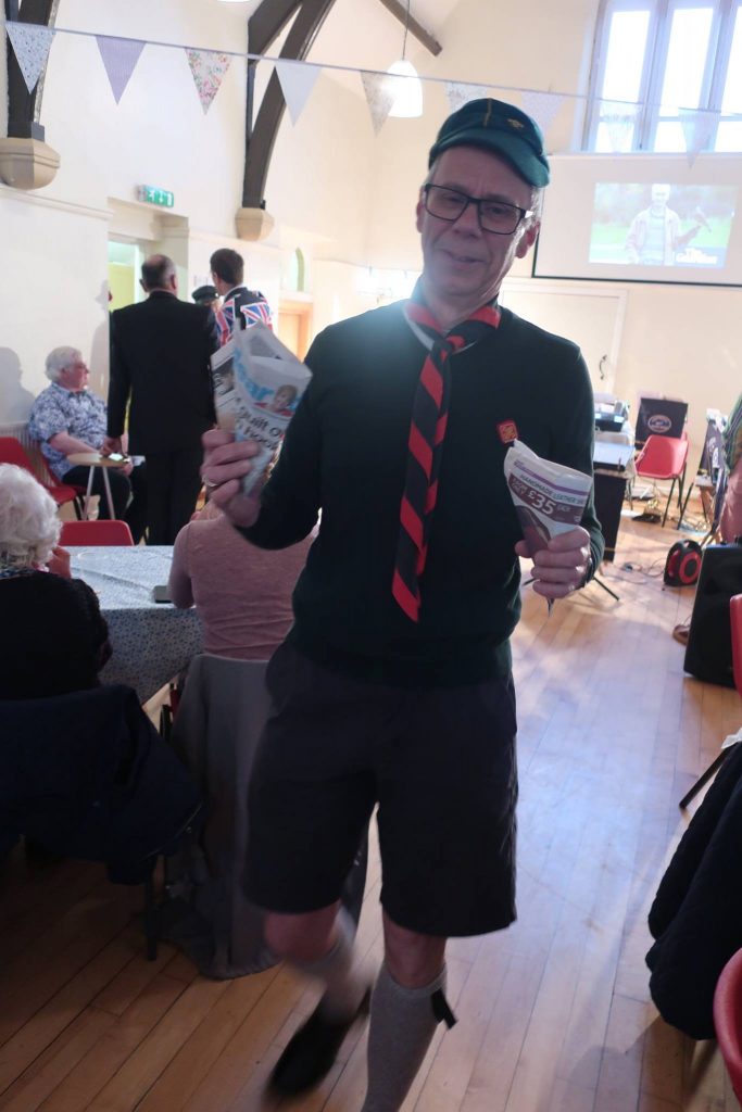 Gwyn dressed as a Cub Scout, holding newspaper cones of chips