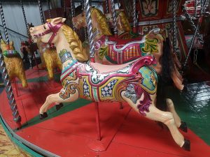 A close up of two carousel style horses