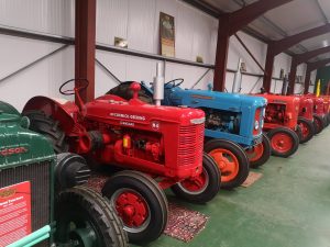 A row of old tractors, red, blue and red.