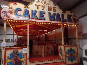 An old fair ground ride where there are moving walkways. 2 girls are walking around it