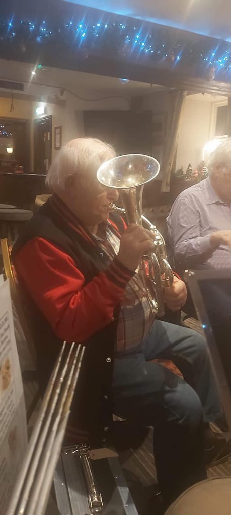 Elvin is playing the tenor horn, in a pub